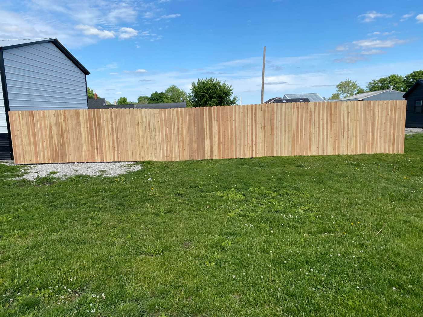 Long finished wood privacy fence across a grassy yard