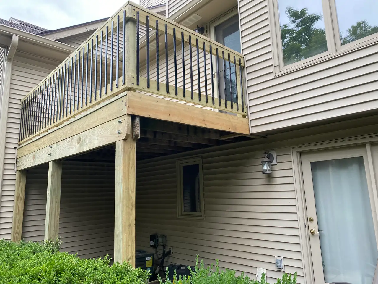 Raised wood deck with black metal railing balusters