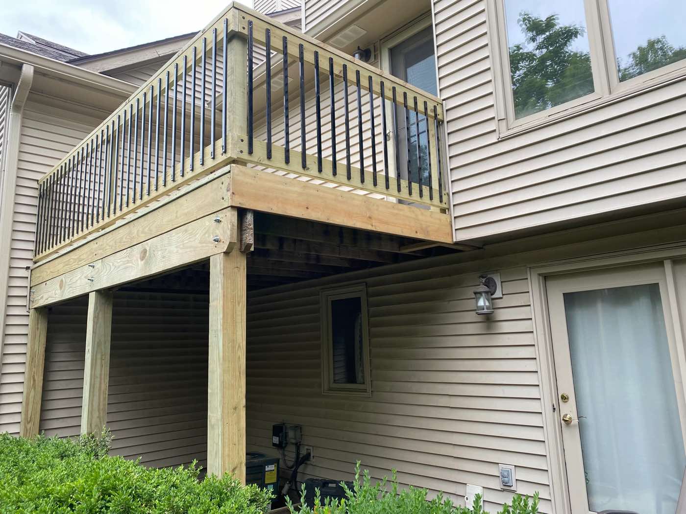 Raised wood deck with black metal railing balusters