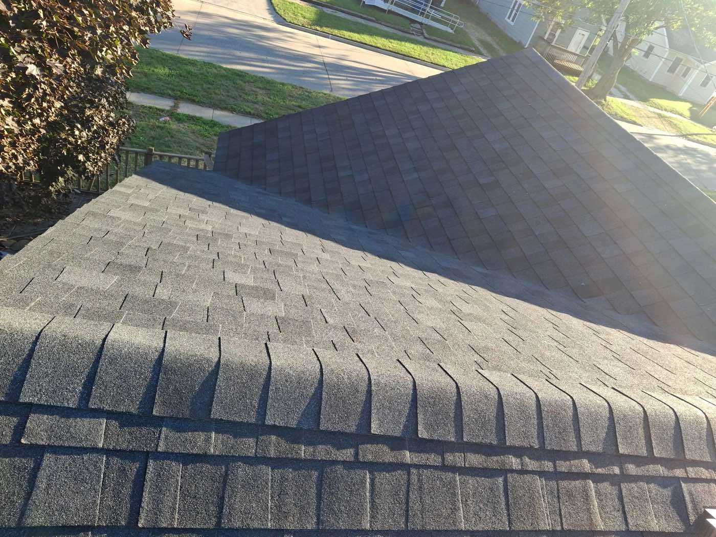 Completed dark architectural shingle roof in sunlight